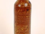 a brown vase that is sitting on a white surface