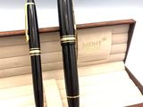 une paire de stylos à plume noirs et dorés rangés dans un coffret en bois