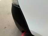 a close up of a white car with a red stripe on it