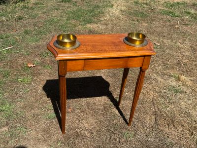 a small wooden table with two bowls on top of it