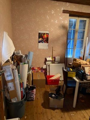 une photo d'une chambre en désordre, encombrée d'objets