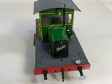 a toy train on a white surface with a green caboose
