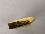 a gold knife that is laying on a white surface