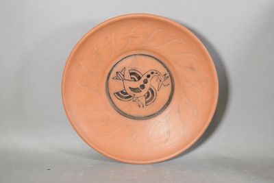 une assiette marron sur laquelle est dessiné un oiseau