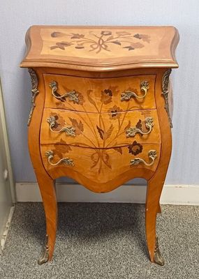 une petite commode en bois ornée d'un motif floral
