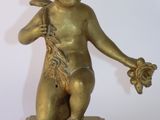 une statue en or représentant un enfant tenant une fleur