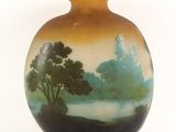 a vase with a painting on it sitting on a table