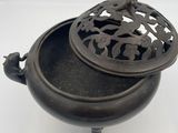 an antique cast iron pot with a lid on a white background