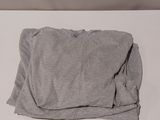 a white bed with a gray blanket on it