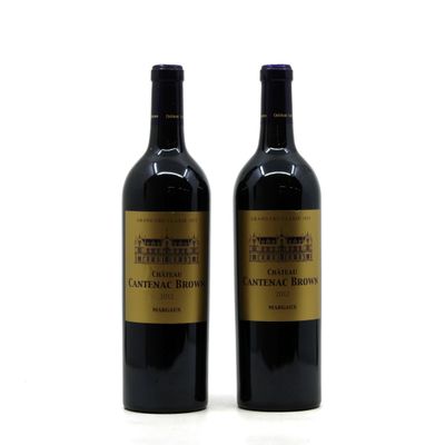 two bottles of wine sitting next to each other on a white surface
