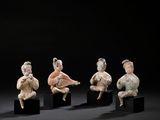 four figurines of people sitting on black blocks in front of a black background