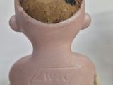 a clay figurine of a man with a cookie on his head
