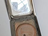 a small compact case with a mirror on top of it