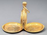 a gold plate with a bird on top of it