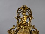 a gold clock with a statue on top of it