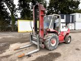 un chariot élévateur rouge garé sur un parking
