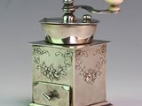 a silver coffee grinder sitting on top of a table