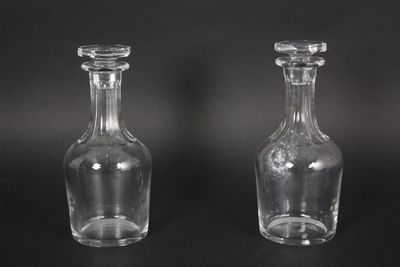 pair of clear glass bottles on a black background