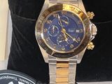 a gold and blue watch sitting on a black velvet bag