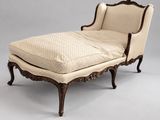 une chaise longue ancienne avec assise rembourrée et repose-pieds