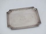 an antique silver tray with a flower design on it