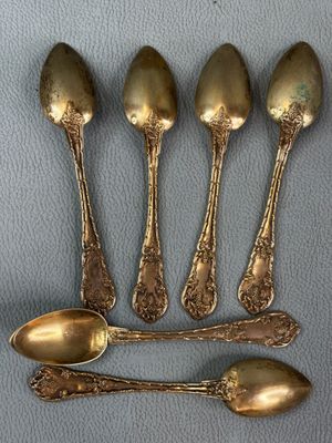 four spoons and a spoon rest on a blue surface