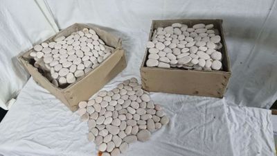 trois boîtes remplies de cailloux blancs posées sur un tissu blanc