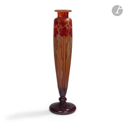 un vase orange posé sur un socle en bois