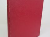 a red book sitting on top of a table next to a white wall