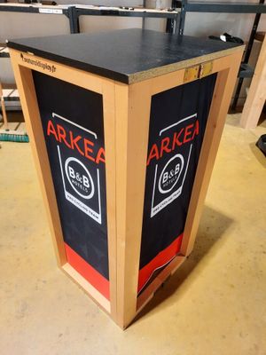 une boîte en bois sur laquelle est collée une étiquette noire et rouge