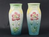 two vases with flowers painted on them on a black background