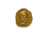 gros plan d'une pièce d'or sur une surface blanche