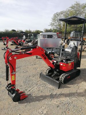 a small red excavator that is parked in the dirt