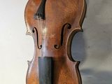 a violin hanging on the wall next to a bag