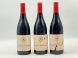 trois bouteilles de vin posées sur une table l'une à côté de l'autre