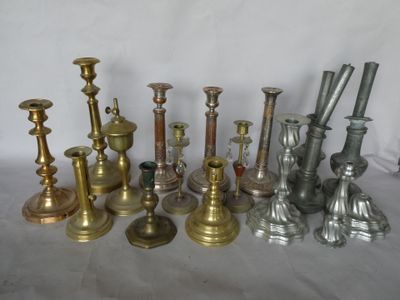 de nombreux bougeoirs en laiton de styles variés sur la table