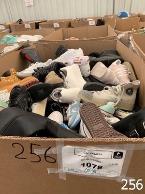 a cardboard box filled with shoes and other items
