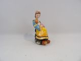 une figurine représentant une femme assise sur un rocher