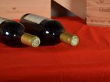 two bottles of wine sitting on a red cloth