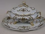 un plateau blanc et doré sur lequel sont posés une tasse et une soucoupe