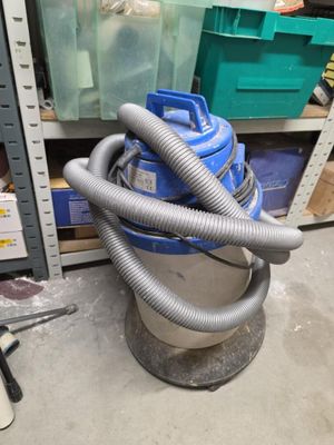 un aspirateur bleu et argent posé dans une pièce