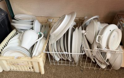 de nombreuses assiettes et casseroles dans un panier posé par terre