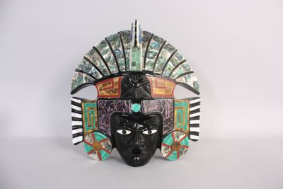 a close up of a mask on a table with a white background