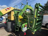 a large green tractor with a yellow trailer parked next to it