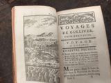 an open book with a picture of a village on it