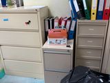 a trash bag sitting on the floor next to a filing cabinet