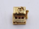a pin with a slot machine on it on a white surface