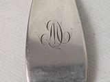 a silver spoon with a monogram on it and a silver spoon with a monogram on it