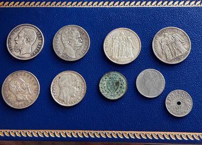 un gros plan sur un livre bleu sur lequel sont posées plusieurs pièces de monnaie