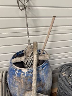 un pot bleu contenant des outils, posé contre un mur
